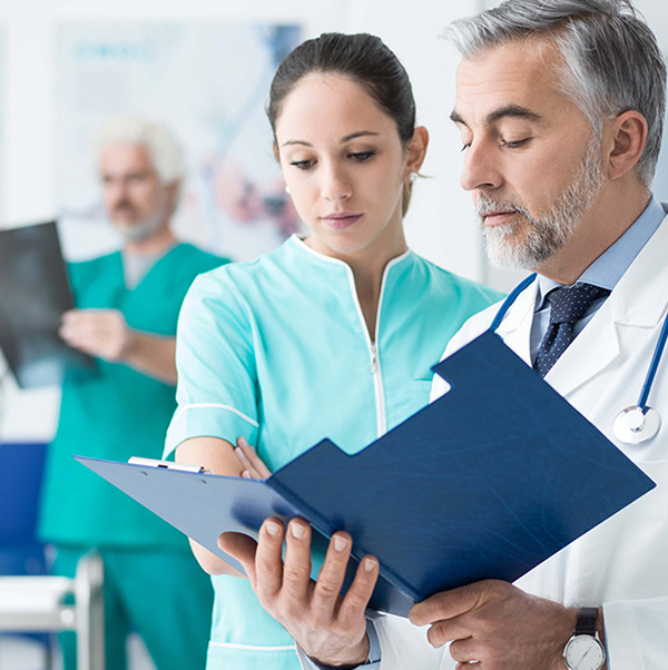 physician assistant reviewing medical documents with a doctor