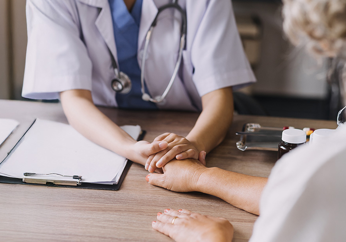 physician holding a patient's hand