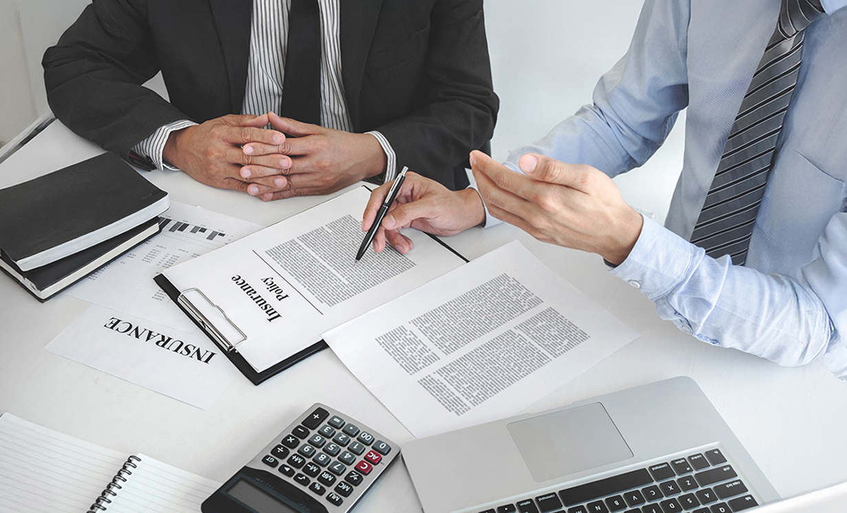 Insurance agent explaining insurance policy to customer in office room