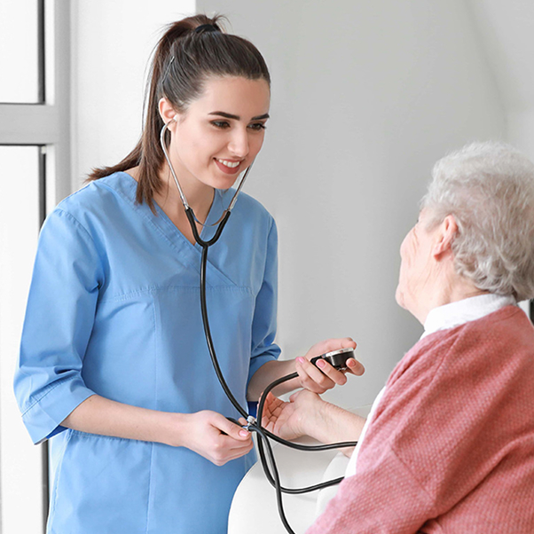 Medical worker examining senior woman in nursing home