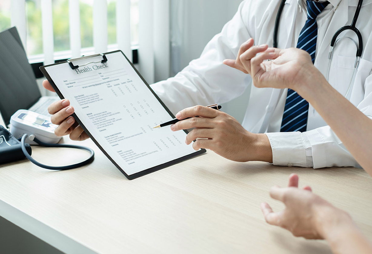 doctor reviewing document on clipboard with patient